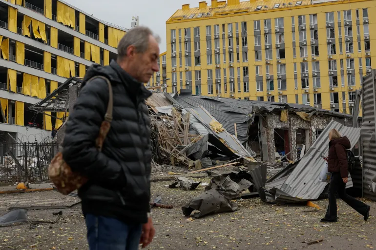 La gente cammina nel sito di un'area residenziale colpita da un attacco missilistico russo in tarda serata, nel mezzo dell'attacco russo all'Ucraina a Kiev, Ucraina, il 30 ottobre 2026. REUTERS/Valentyn Ogirenko