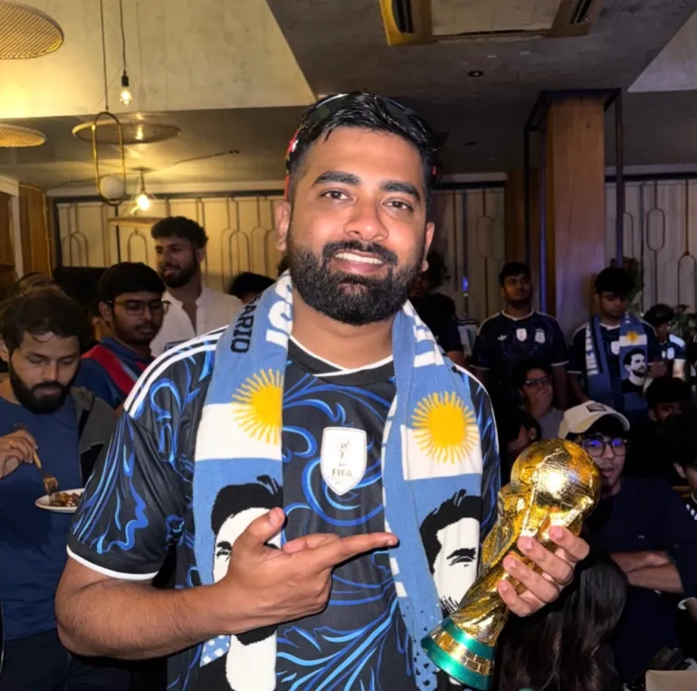 Sagar Shinde, un tifoso argentino di Mumbai, in India, posa con una miniatura della Coppa del Mondo FIFA durante una proiezione [Courtesy of Sagar Shinde]